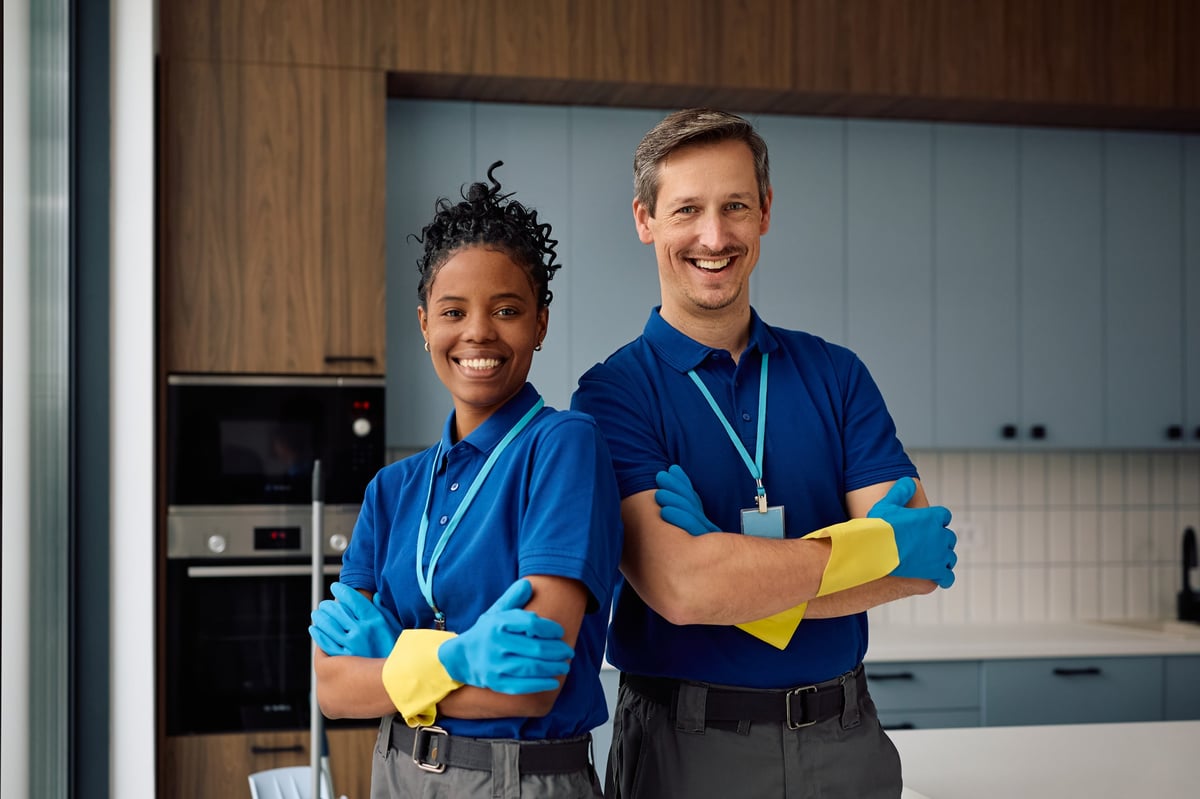 Happy diverse professional cleaners standing confidently together